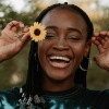 a woman holding a flower and smiling